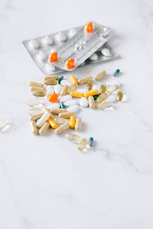 Verschiedene Nahrungsergänzungsmittel – Kapseln auf weißem Tisch mit Maßband